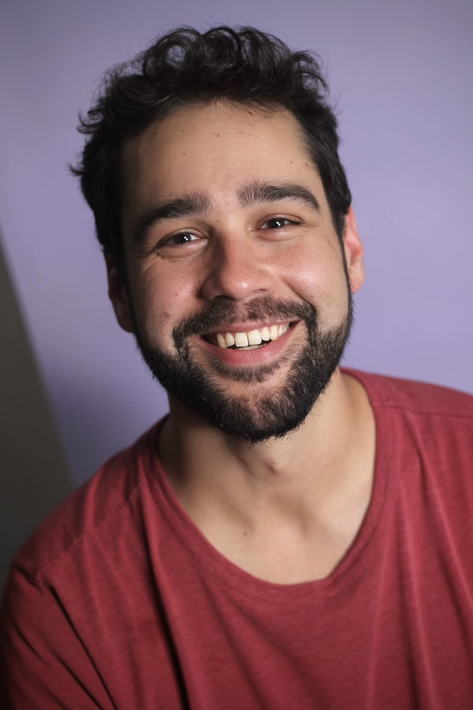 Niku Dhillon smiling, wearing a red shirt